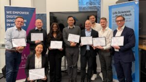 The cohort of the 2025 NHA MArket Access Accelerator, standing in a line holding their certificates and smiling.